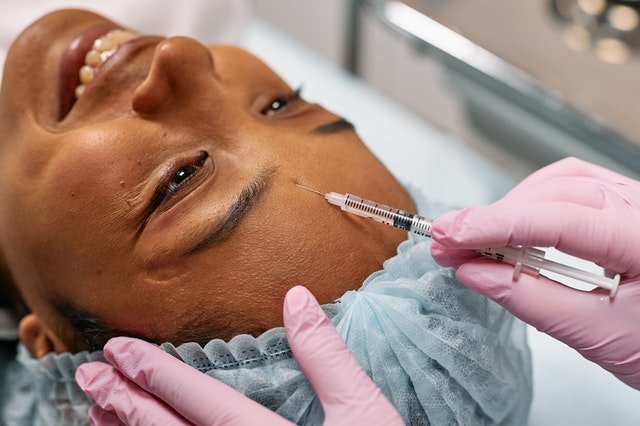 Woman getting a botox on forehead